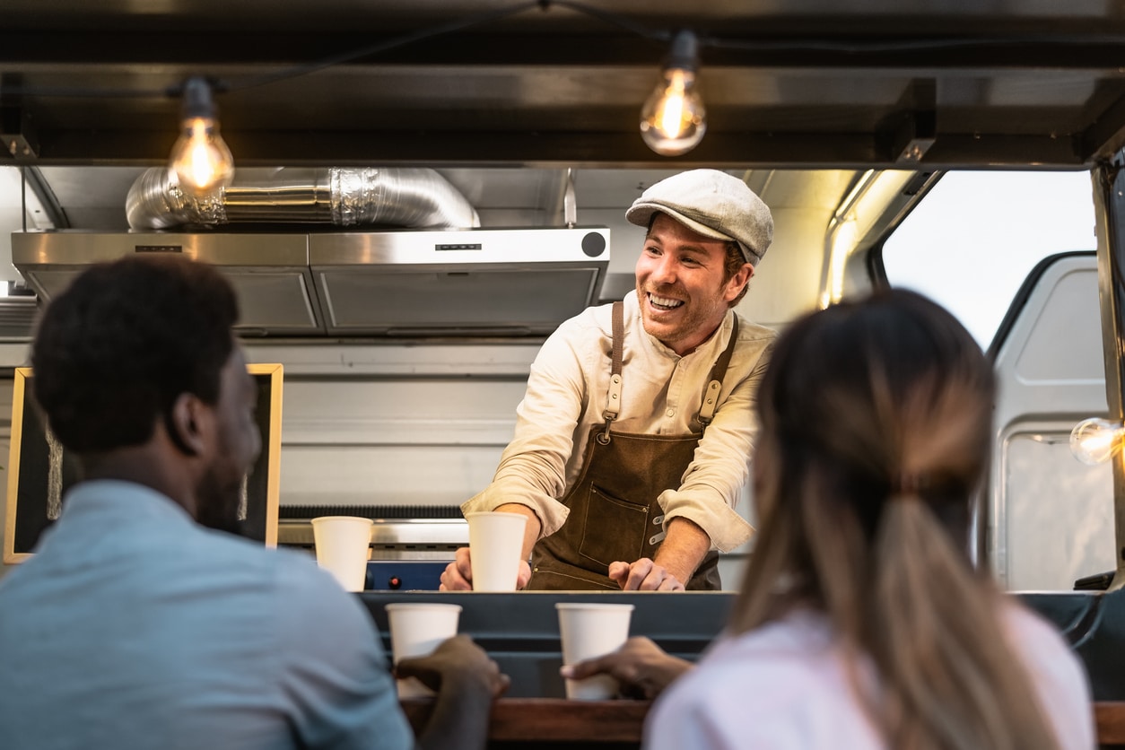 Happy multiracial people buying meal from street food truck market - Modern business and take away concept